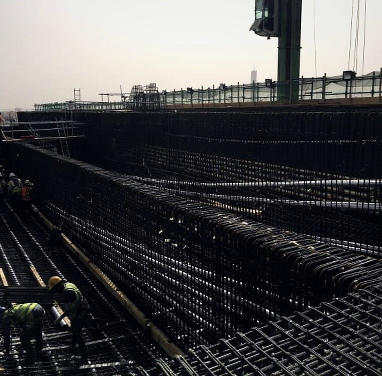 Steel fixers working across a heavy raft reinforcement mat