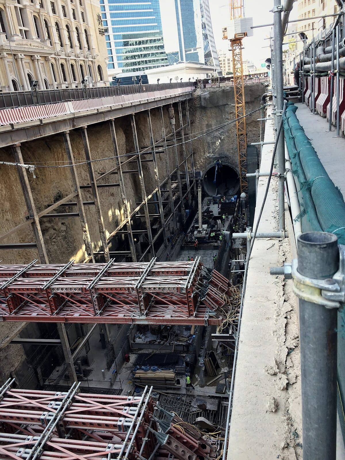 Strutted excavation of an underground metro station box, with the tunnel opening at its far end